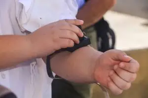 ילד לובש תפילין בזרוע במהלך טקס בר מצווה